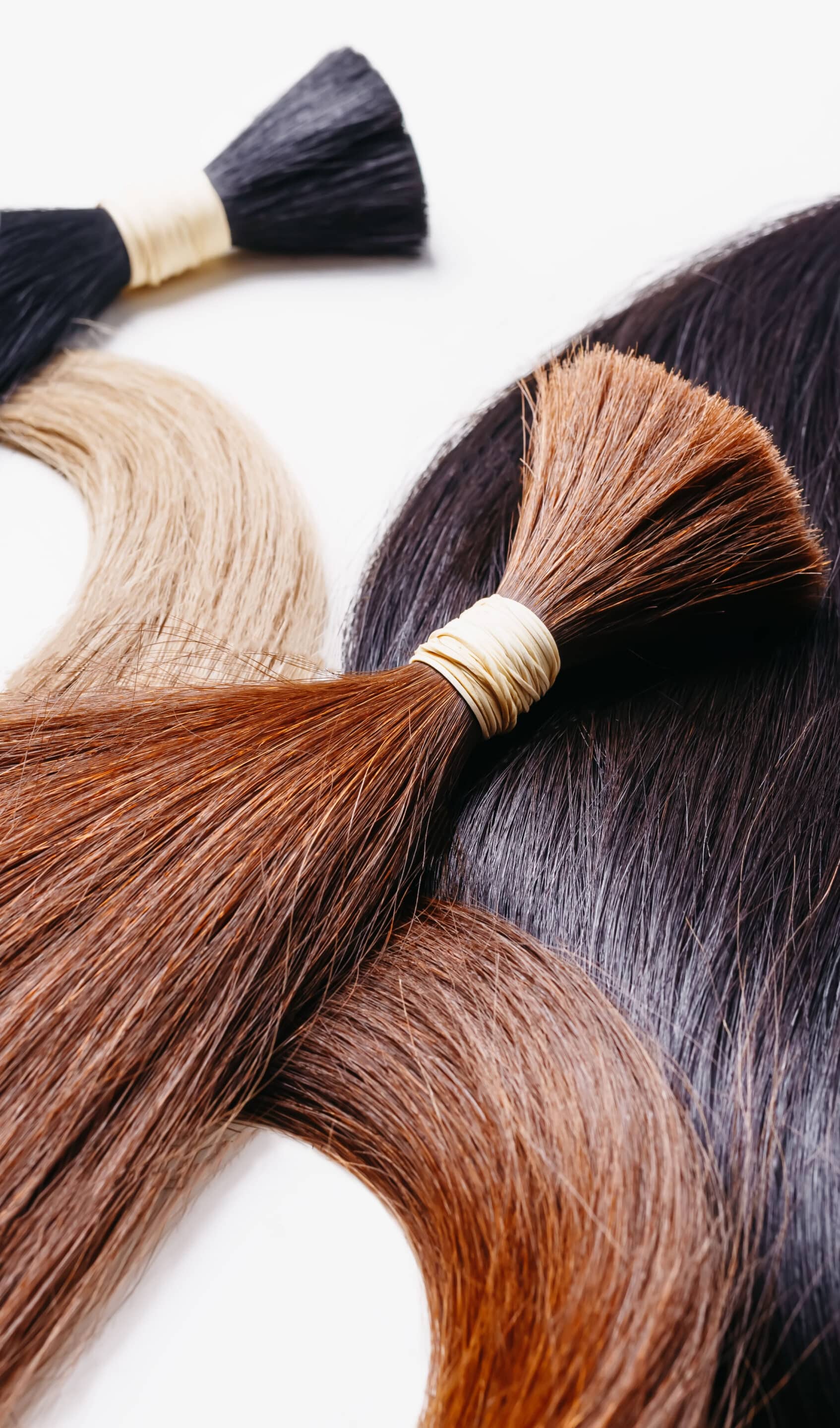 Hair,Extensions,Of,Three,Colors,On,A,White,Background,With